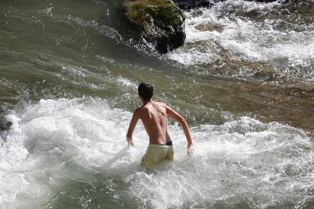 Granadinos y visitantes se las apañan en las calles para no sufrir mucho el enorme calor de estos días