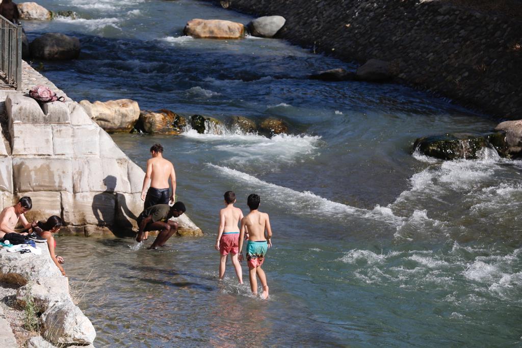 Granadinos y visitantes se las apañan en las calles para no sufrir mucho el enorme calor de estos días