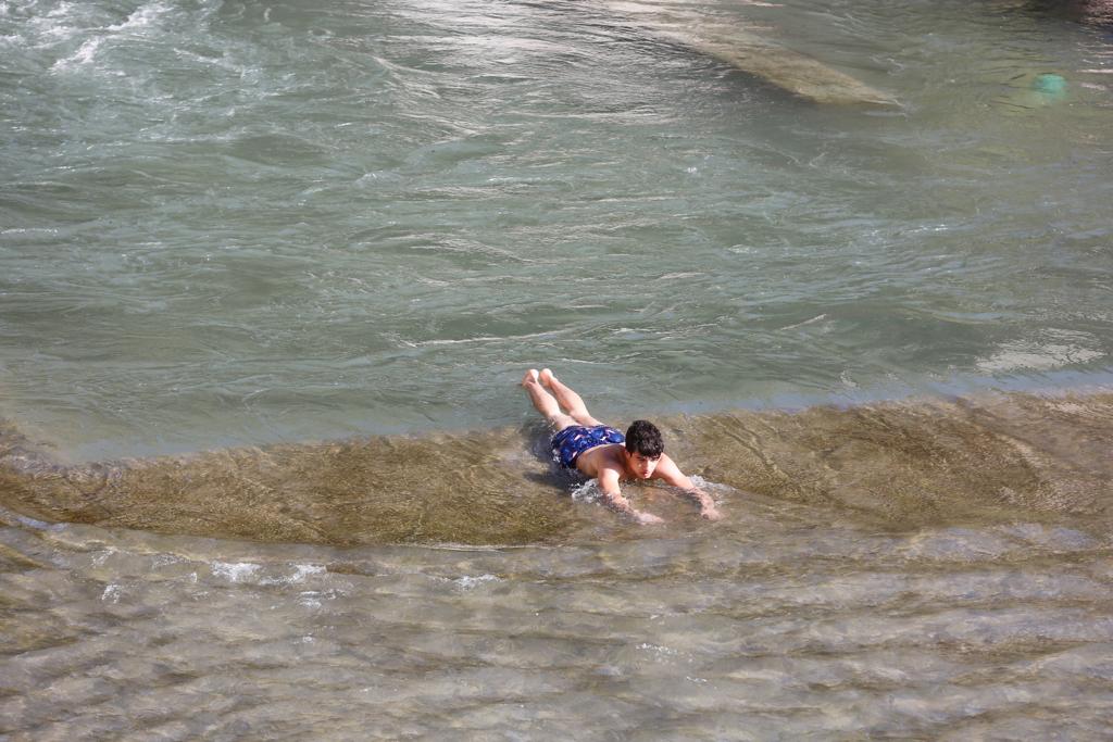 Granadinos y visitantes se las apañan en las calles para no sufrir mucho el enorme calor de estos días
