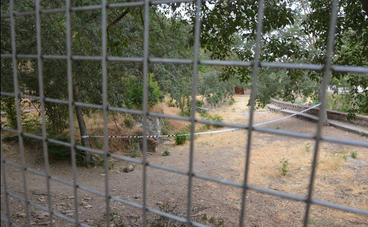 El cordón policial situado alrededor del lugar del fallecimiento se puede ver a través de la valla. 