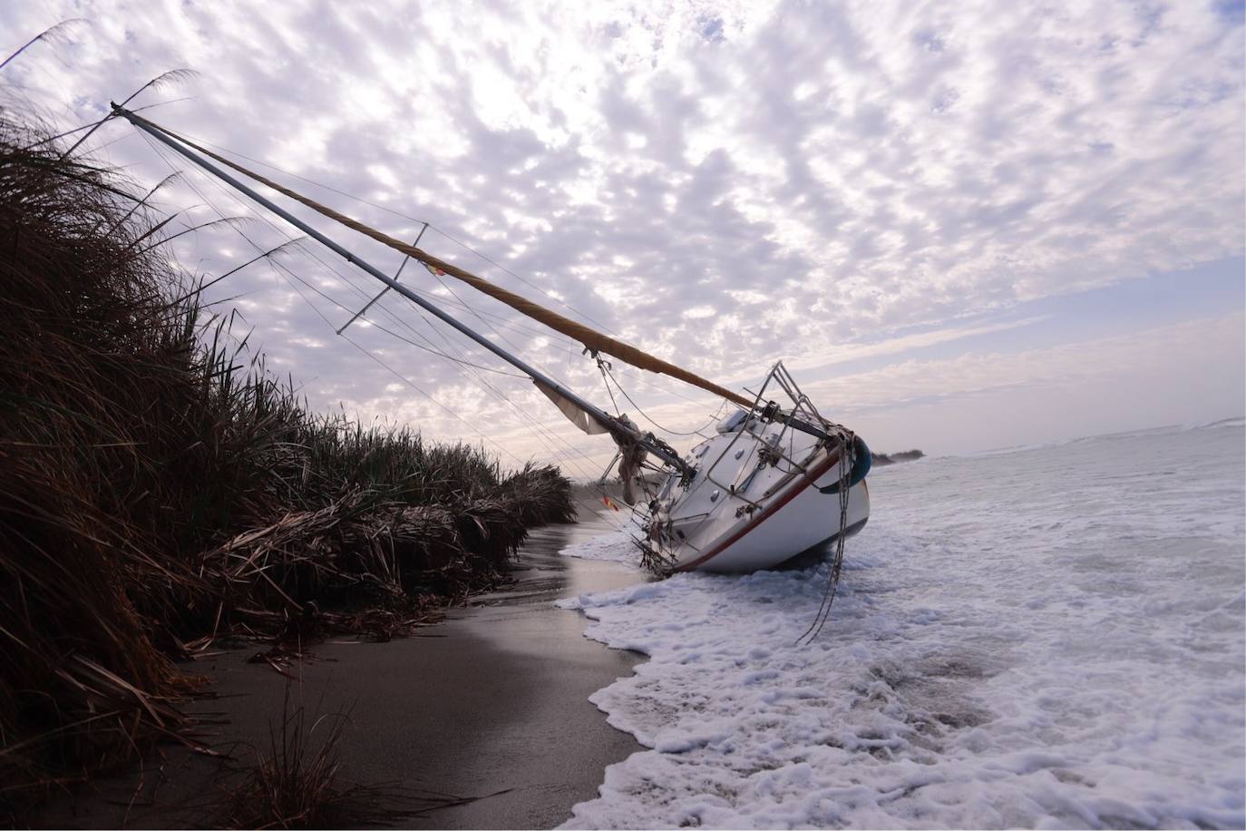 Fotos: Piden ayuda para sacar un velero de una playa de Salobreña