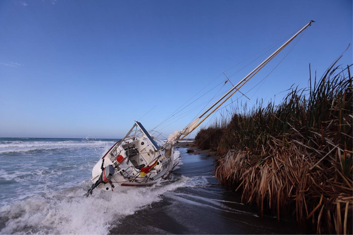 Fotos: Piden ayuda para sacar un velero de una playa de Salobreña