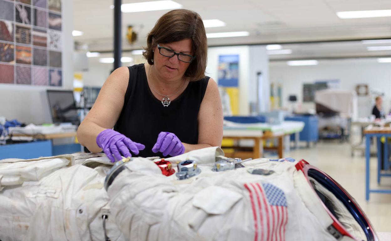 Una empleada del Instituo Smithsonian trabaja sobre el traje espacial del Apolo 11 de Neil Amstrong.