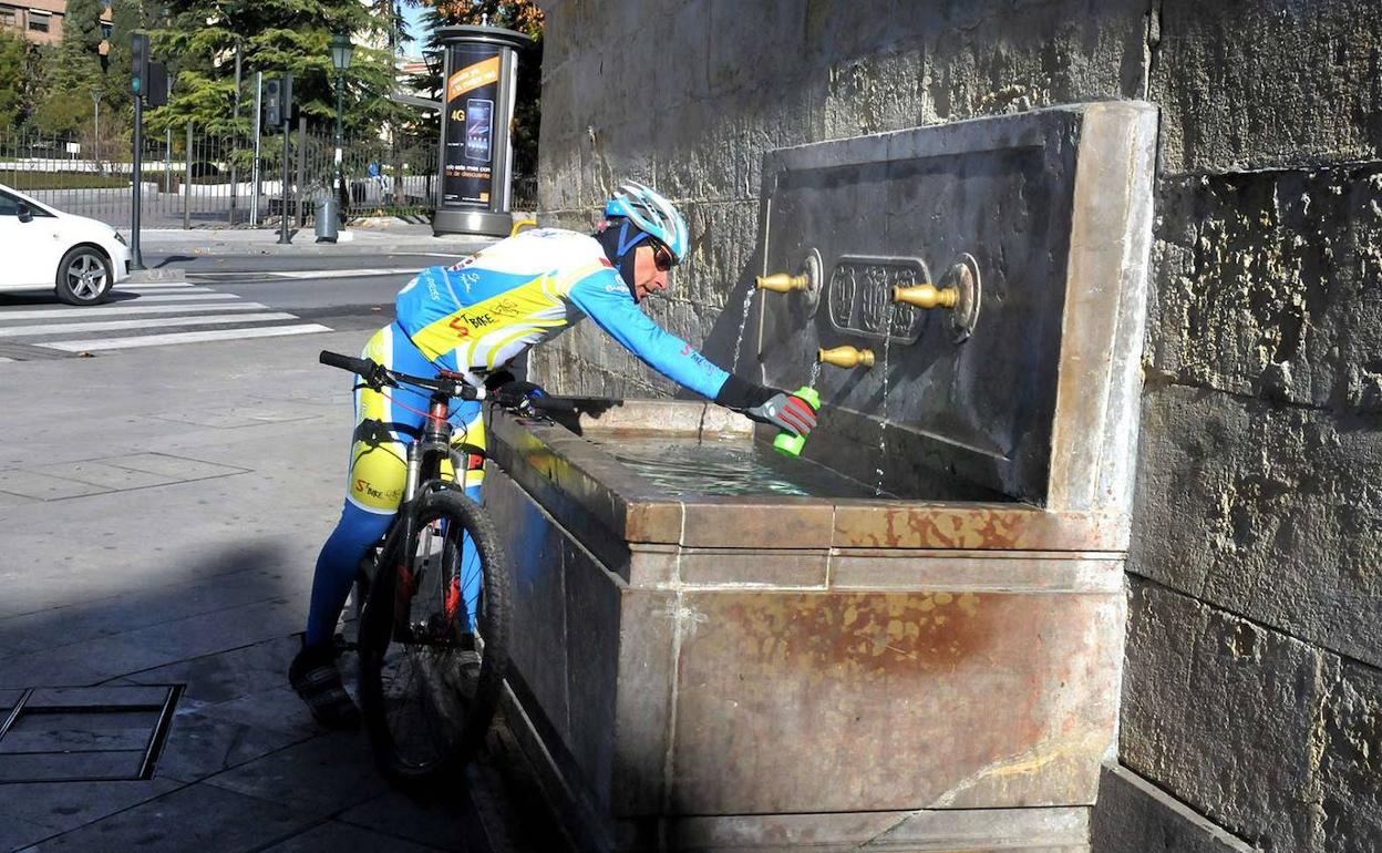 Un ciclista rellena su botella de agua