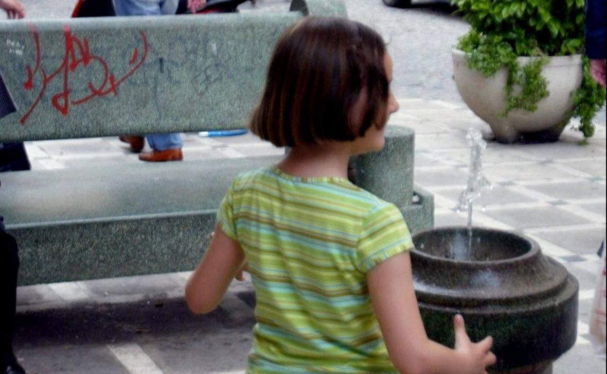Niña junto a la fuente de beber en la calle Navas de Tolosa, en Jaén. 