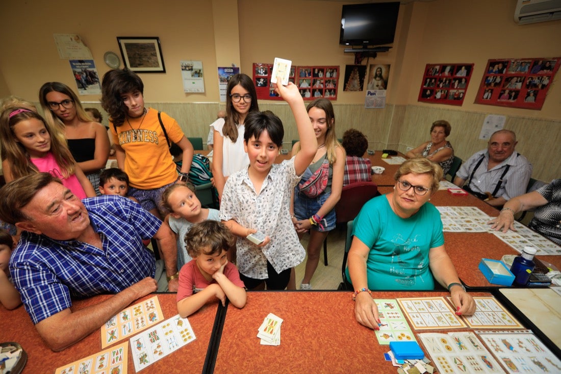 Los niños cantan los 'números' del bingo mientras los mayores juegan.