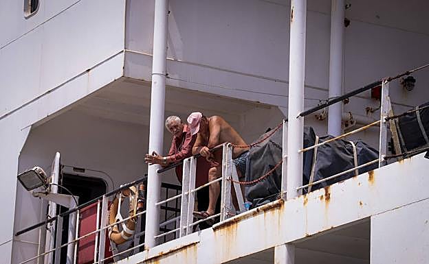 Dos de los tripulantes asomados a las barandillas de la cubierta.