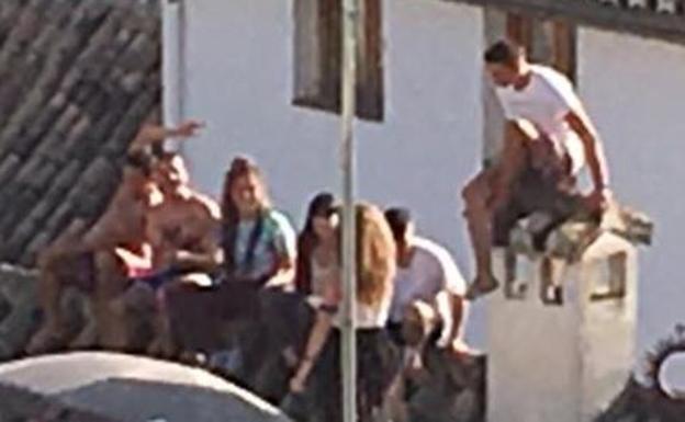 Un grupo de jóvenes subido al tejado de un edificio del Albaicín. 