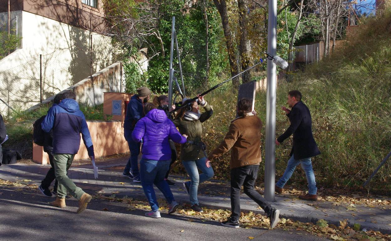 Ríos (a la izquierda, de espaldas), dirige a Federico Aguado mientras este camina por la calle enviando mensajes de voz con el móvil. 