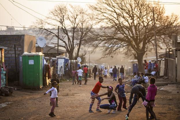 Niños juegan al atardecer en las calles de la barriada de Kliptown, en Soweto.