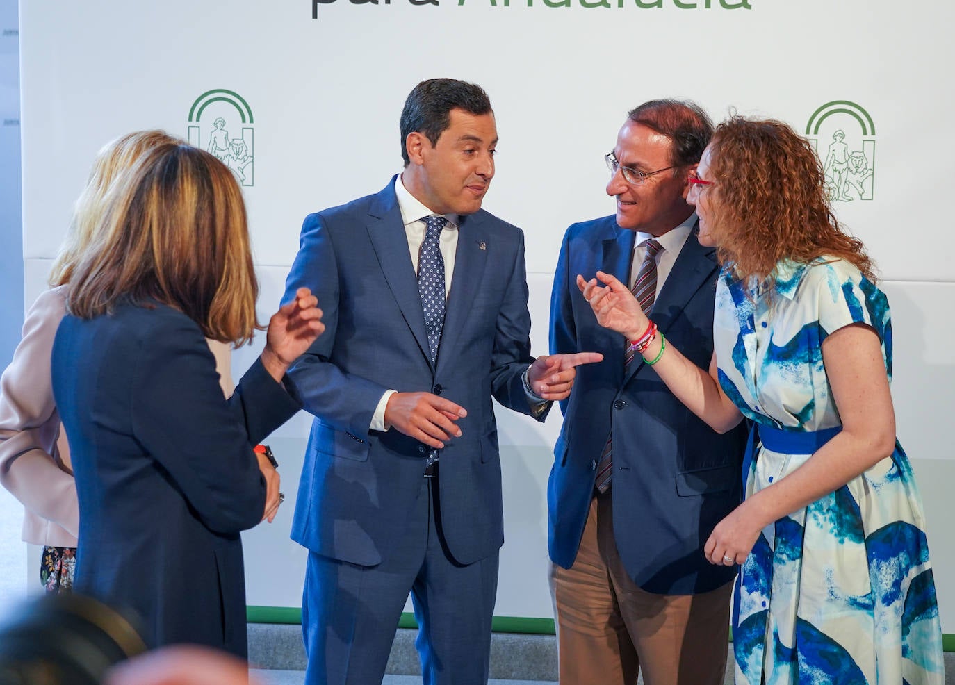 Juanma Moreno en distendida charla con el presidente de la patronal y las dirigentes de CC OO y UGT.