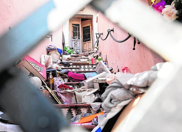Acceso a la vivienda de un vecino que acumula basura y enseres sin parar.