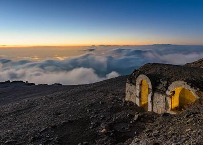 Imagen secundaria 1 - Refugio Elorrieta en invierno; con un mar de nubes bajo los cerros; imagen del edificio que se quiere arreglar 