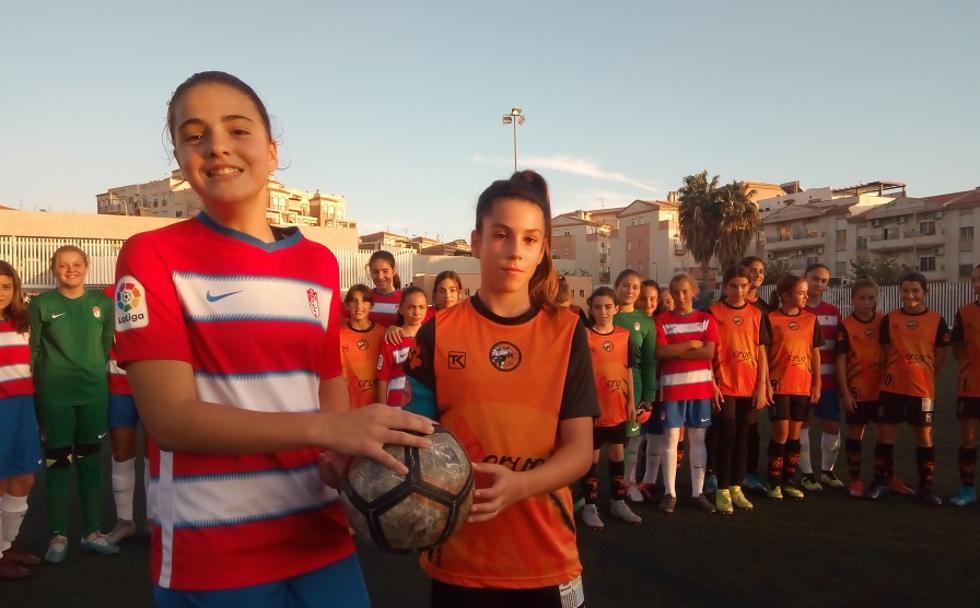 Las capitanas del Granada CFy elCultural Asako Motril comparten el balón minutos antes de que diera comienzo el encuentro ayer, en el Hermanos Callejón