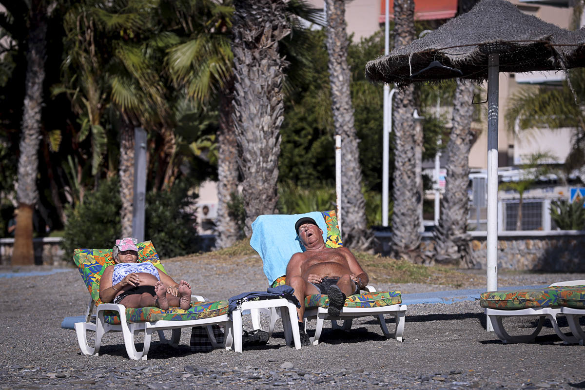 Decenas de turistas ya se encuentran en las playas del litoral granadino, que registrará una temperatura primaveral este fin de semana 