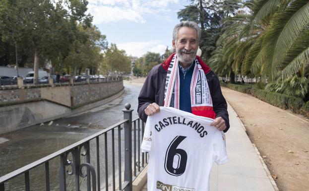 Ángel Castellanos posa sonriente junto a la camiseta que le regaló el Valencia por el centenario del club, con una bufanda del Granada al cuello. 