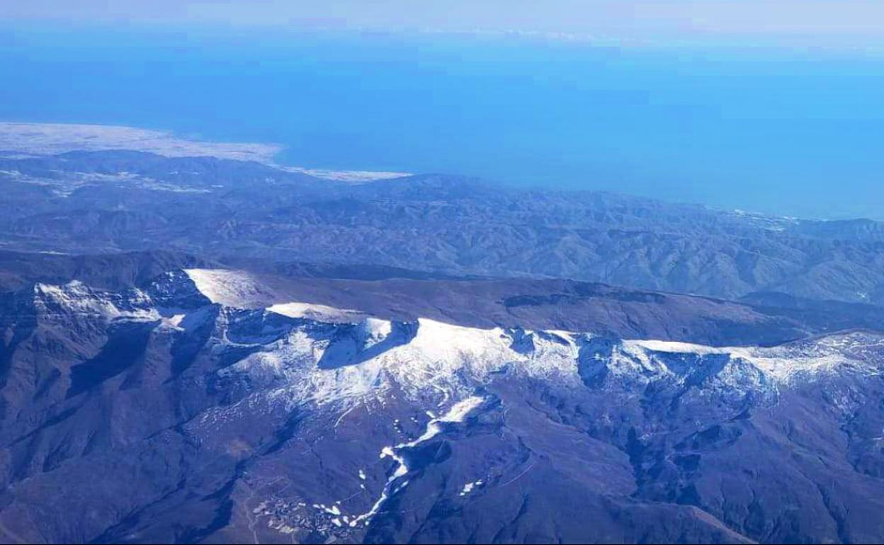 De izquierda a derecha, nevados, los picos de la alcazaba, Mulhacén, los Machos y Veleta, al fondo el mar de Alborán y los invernaderos de El Ejido; abajo, la estación de esquí 