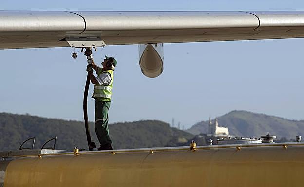 Un operario trabaja en el repostaje de combustible de un avión en el aeropuerto internacional de Río de Janeiro.