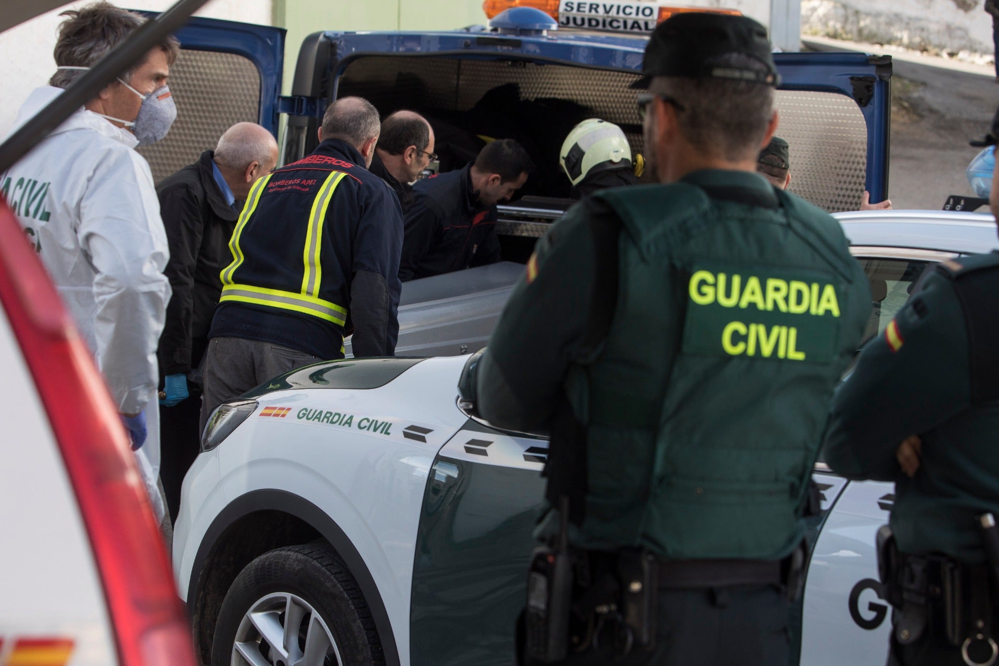 Miembros de la funeraria proceden a guardar uno de los féretros en el vehículo.