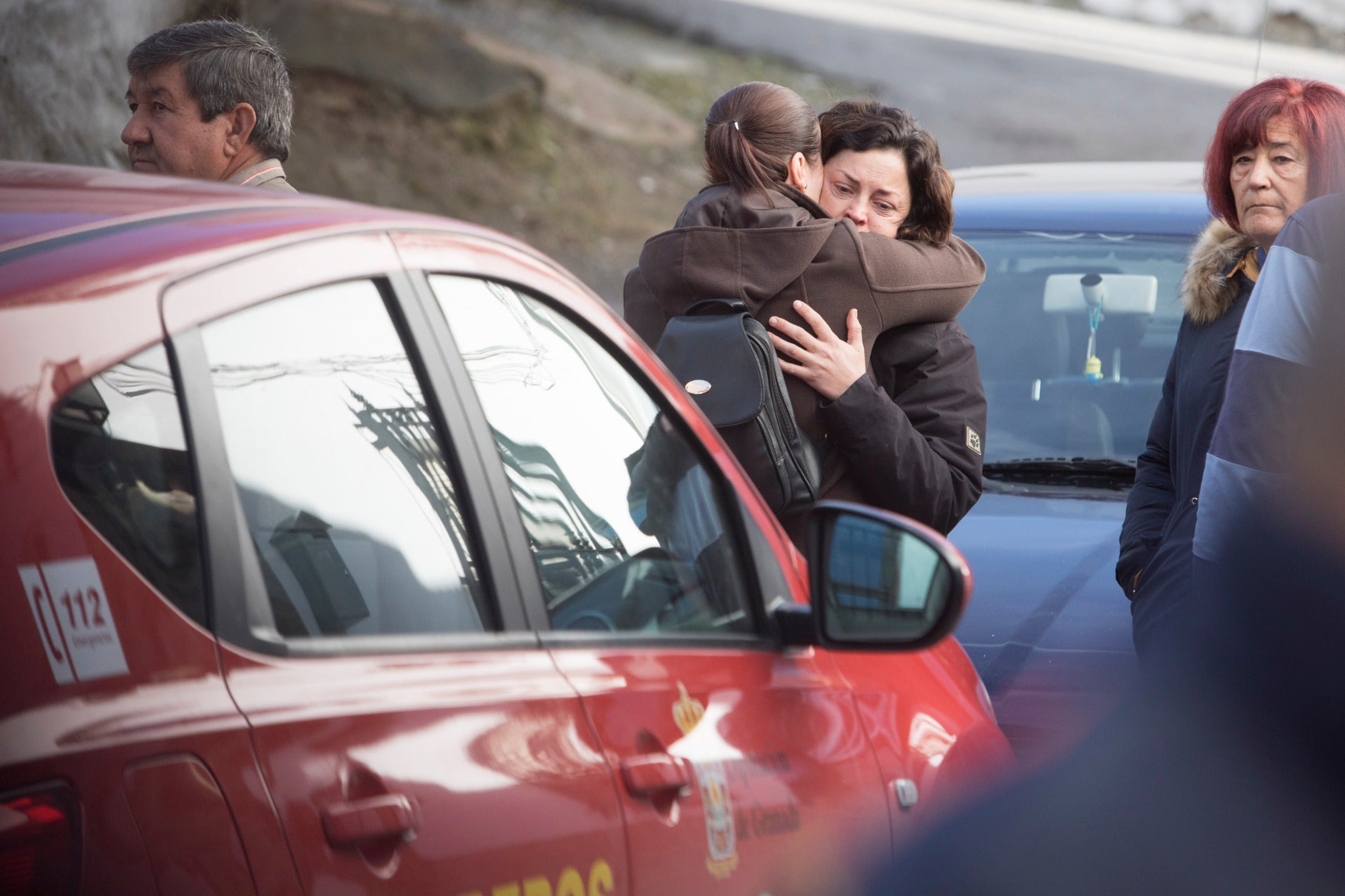 Miembros de la funeraria proceden a guardar uno de los féretros en el vehículo.