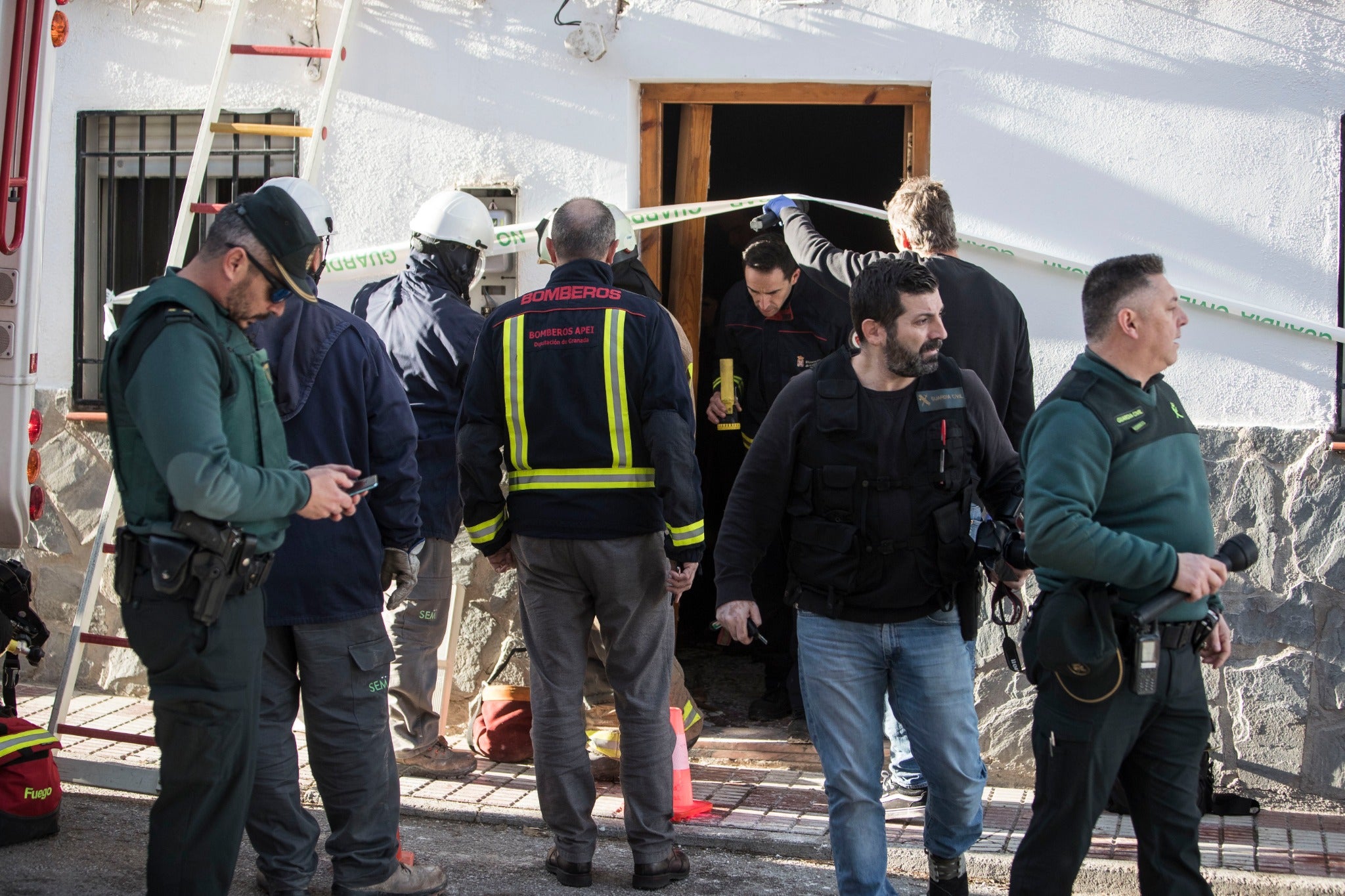 Miembros de la funeraria proceden a guardar uno de los féretros en el vehículo.