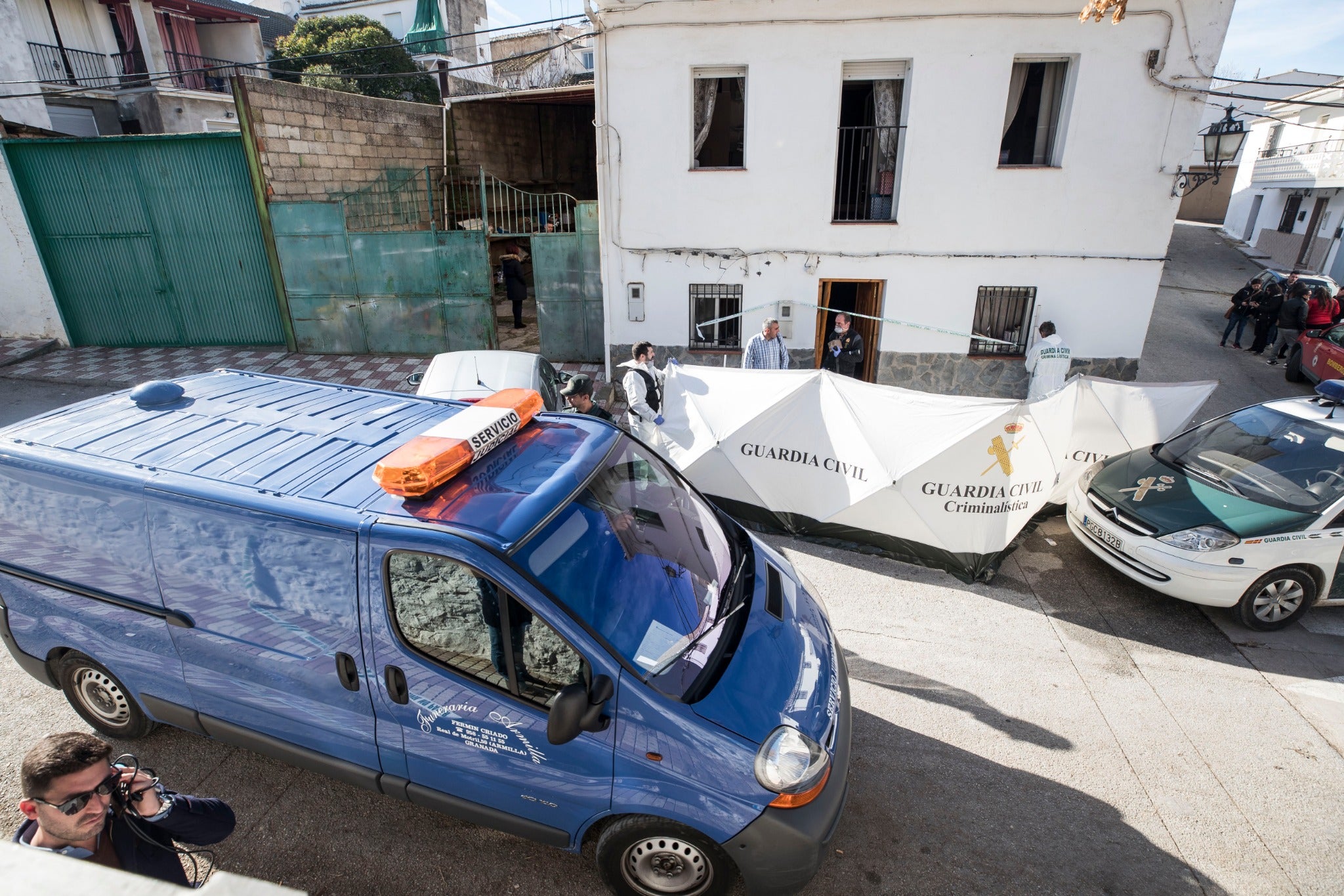 Miembros de la funeraria proceden a guardar uno de los féretros en el vehículo.