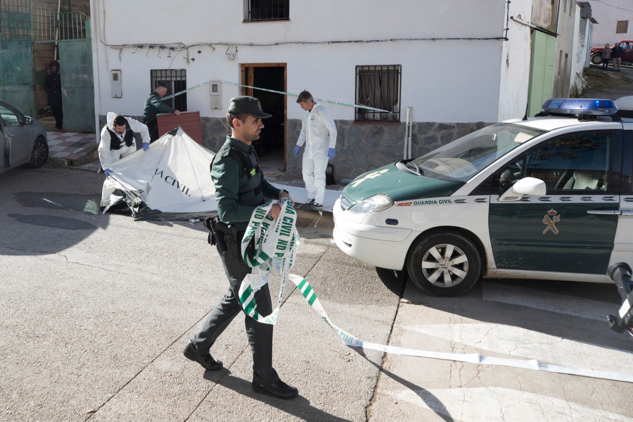 Miembros de la funeraria proceden a guardar uno de los féretros en el vehículo.