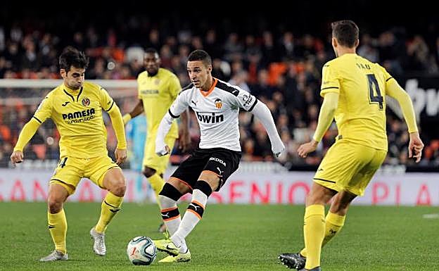 Rodrigo, jugador del Valencia, rodeado de defensas del Villarreal 