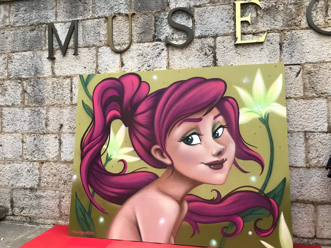 Una joven realiza un grafiti sobre un mural