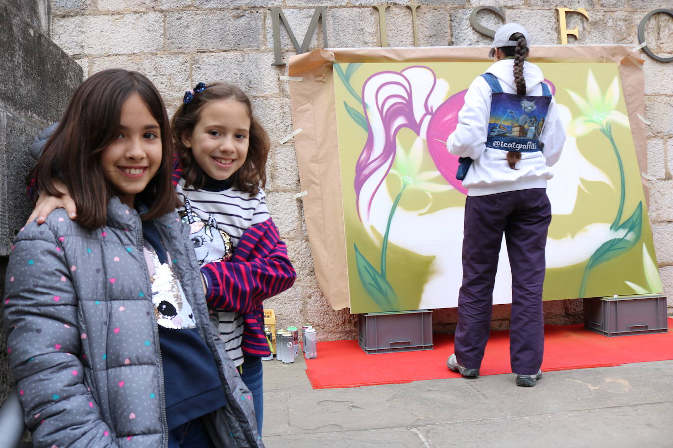 Una joven realiza un grafiti sobre un mural