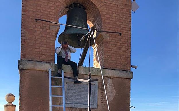 Imagen. El operario se protege con las manos del sonido de la campana.