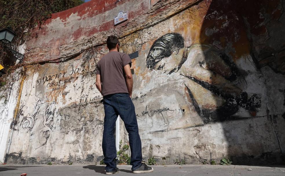 El Niño de las Pinturas contempla el mural que quieren rehabilitar pero que el Ayuntamiento de Granada no permite.