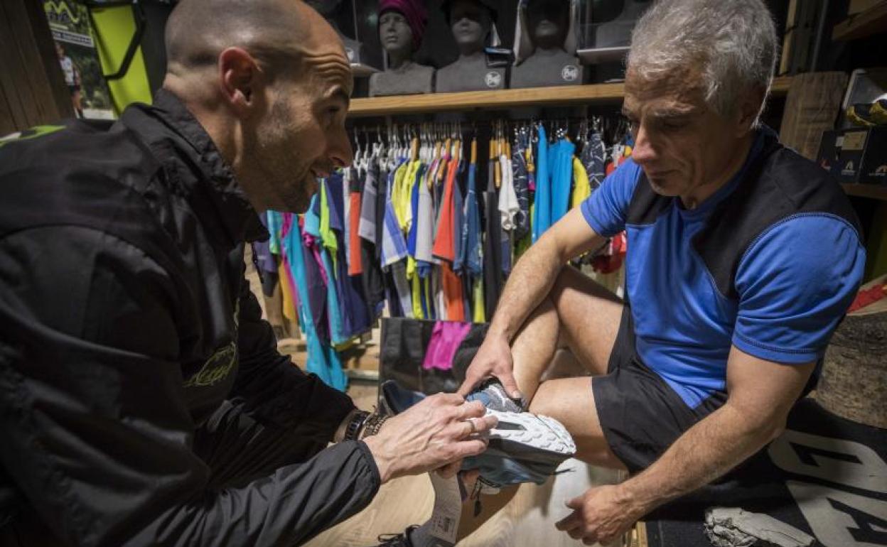 Un cliente es asesorado en Bicha Trail para comprar unas zapatillas