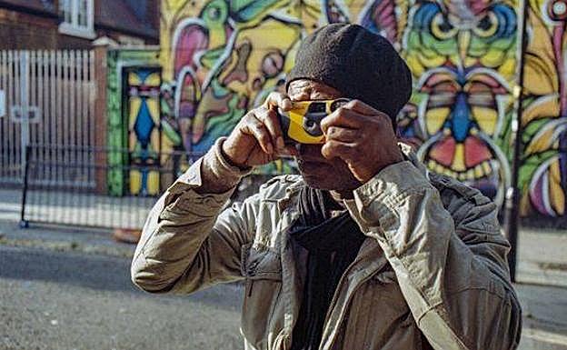 Sunny oculta su rostro con una cámara de fotos.