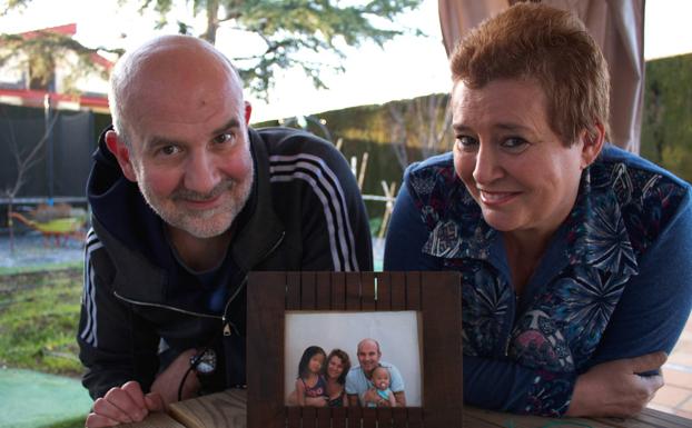 Mario y Chari posan con una foto de sus hijas adoptadas. 