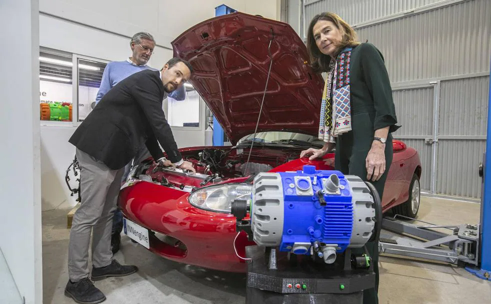 Roberto Lendaro, Juan Garrido y Ana Martín-Moreno, junto al Mazda MX5 en el que están probando su motor de combustión interna de dos tiempos. Delante, un modelo del motor impreso en 3D.