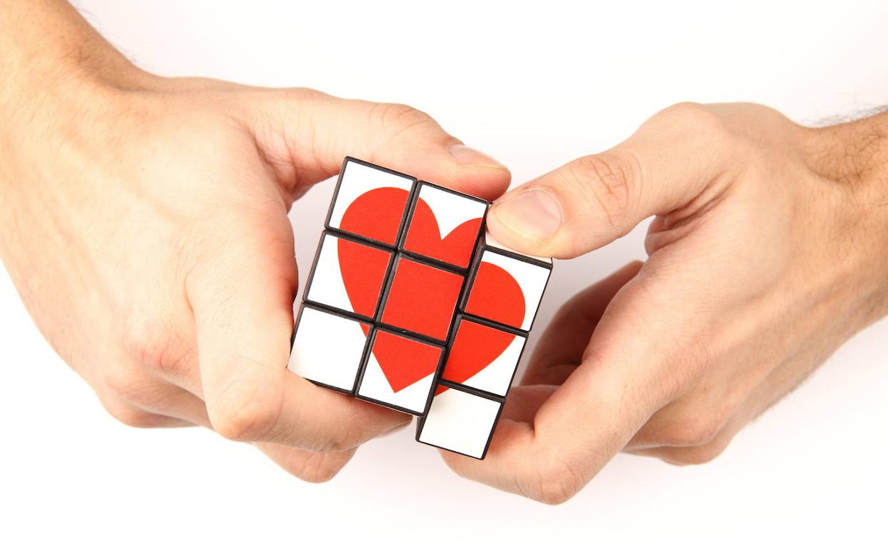 Manos desmontan un cubo con una figura de corazón
