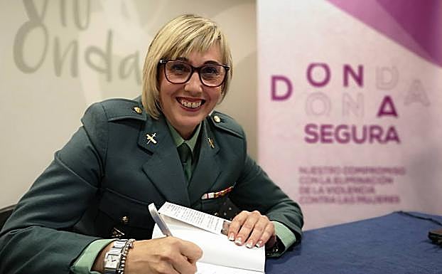 La agente Contreras firma un ejemplar de su libro.