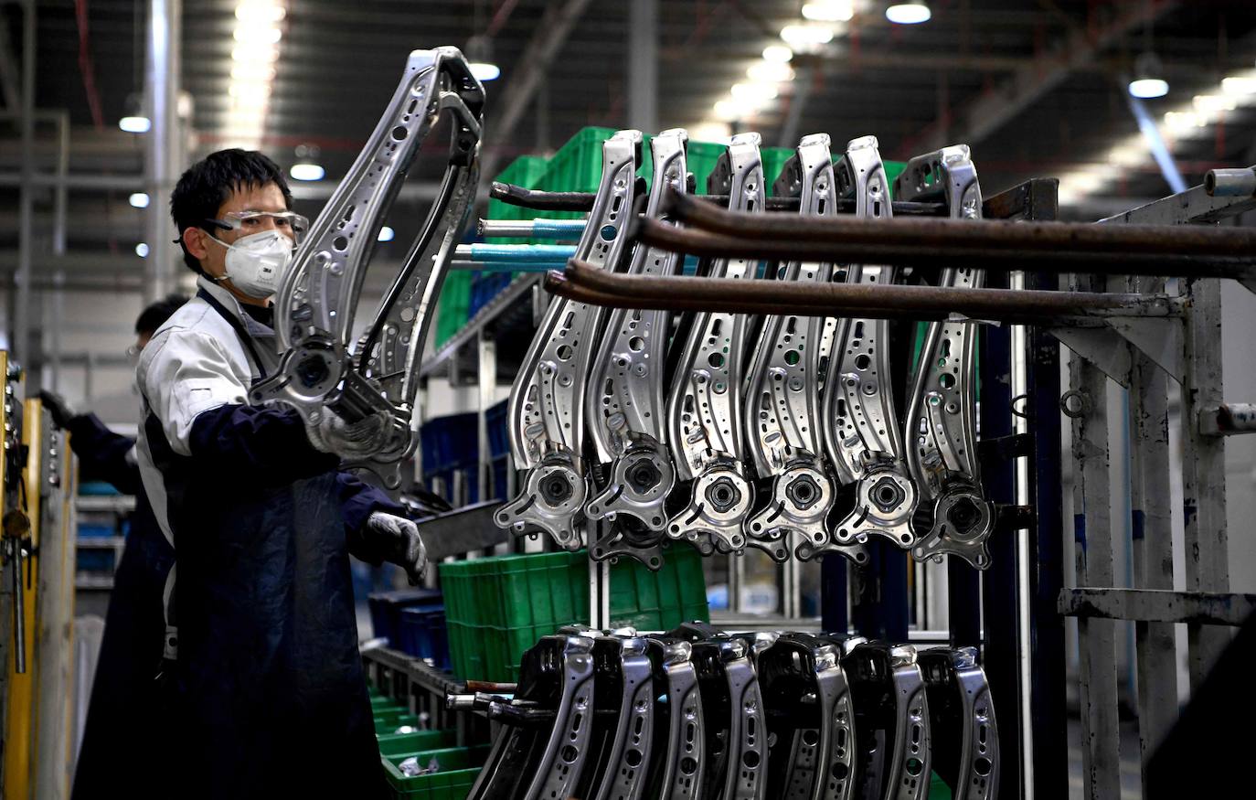 Un trabajador protegido con mascarilla en una fábrica china. 