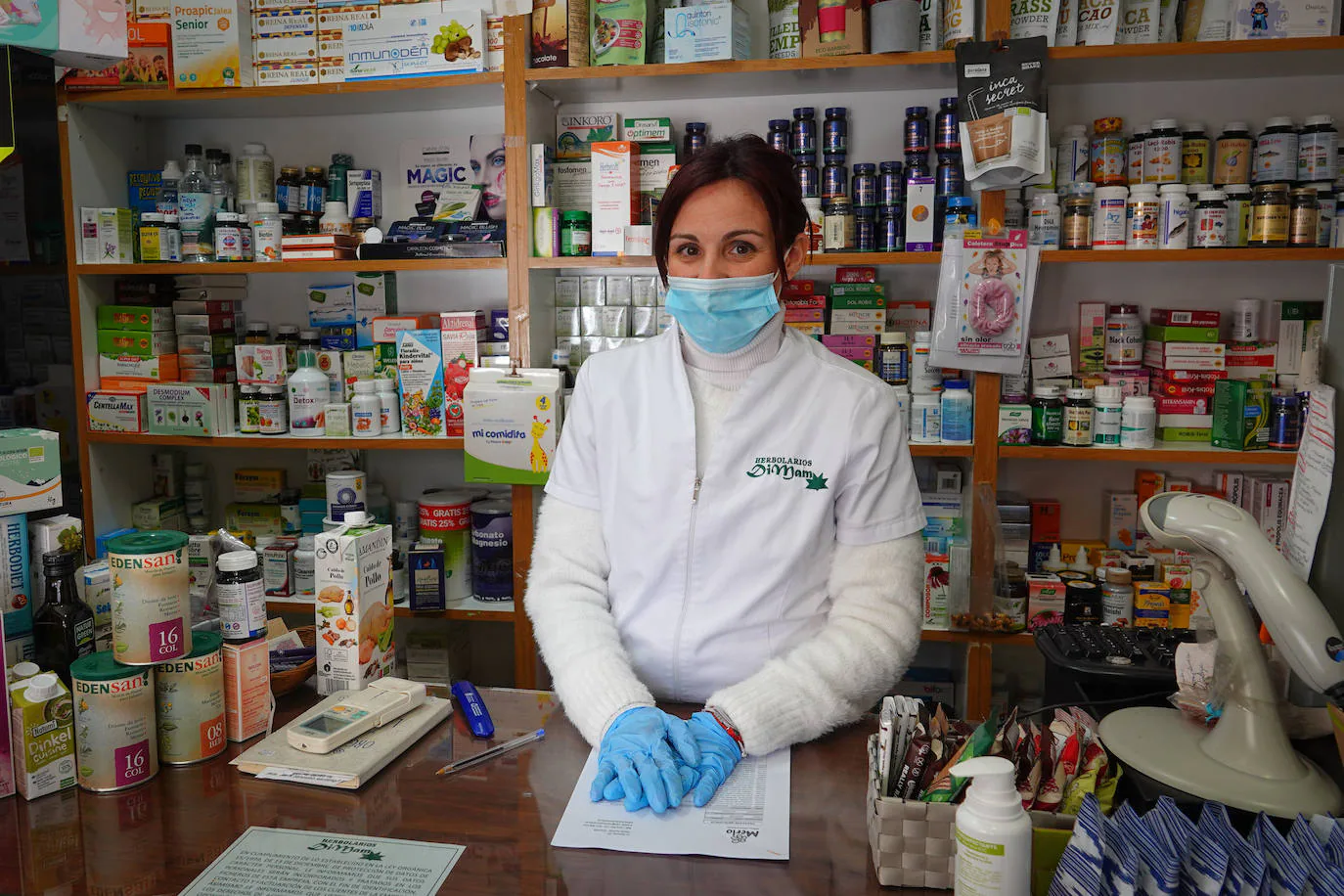 Patricia, en el mostrador del Herbolario Dimam del Zaidín, respaldada por algunas de sus infusiones y tratamientos.