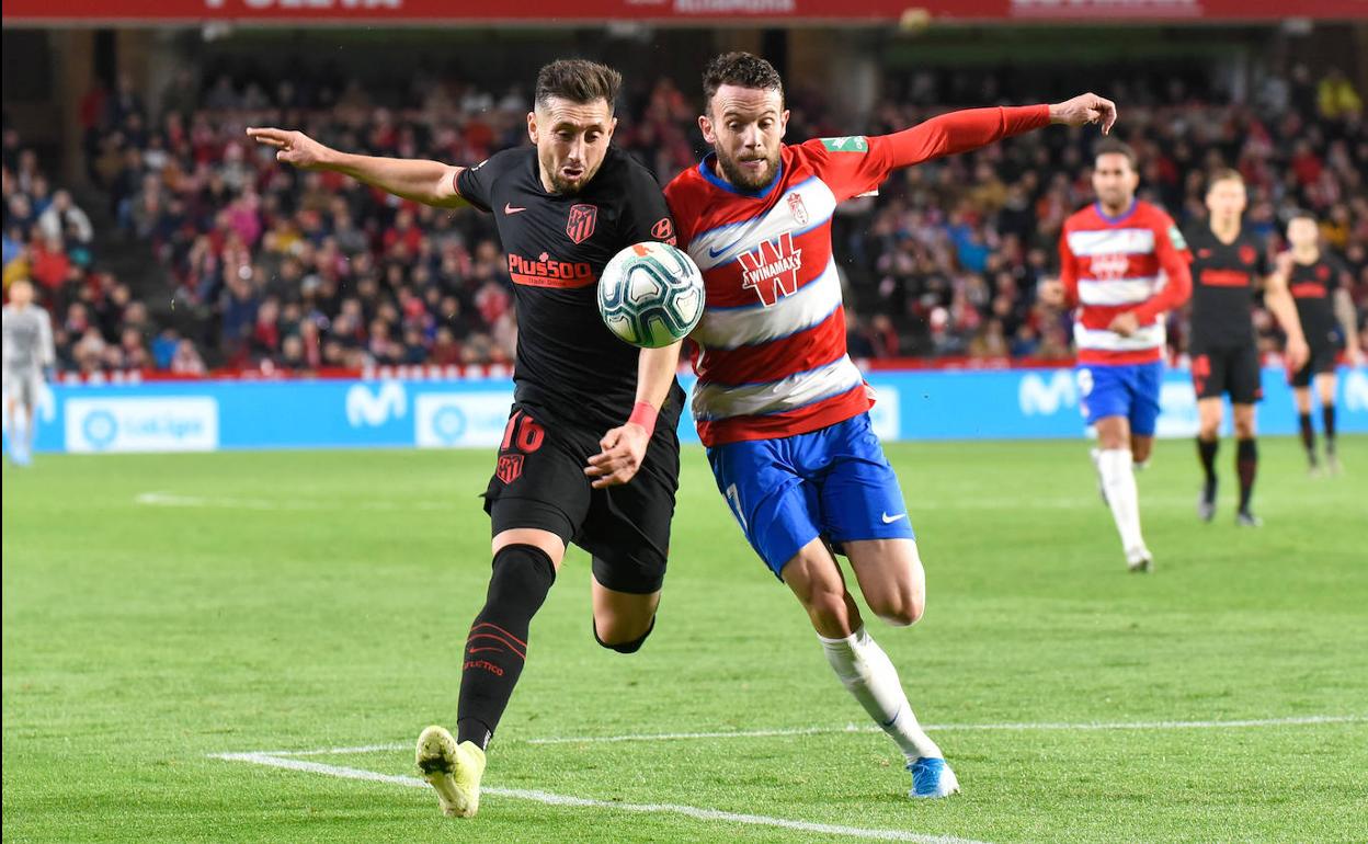Quini disputa un balón con Héctor Herrera en Los Cármenes. 