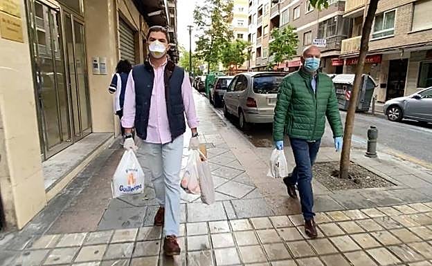 Francisco y José Antonio llevan la compra a Pepe y Paqui, que viven en la calle Pedro Antonio de Alarcón.