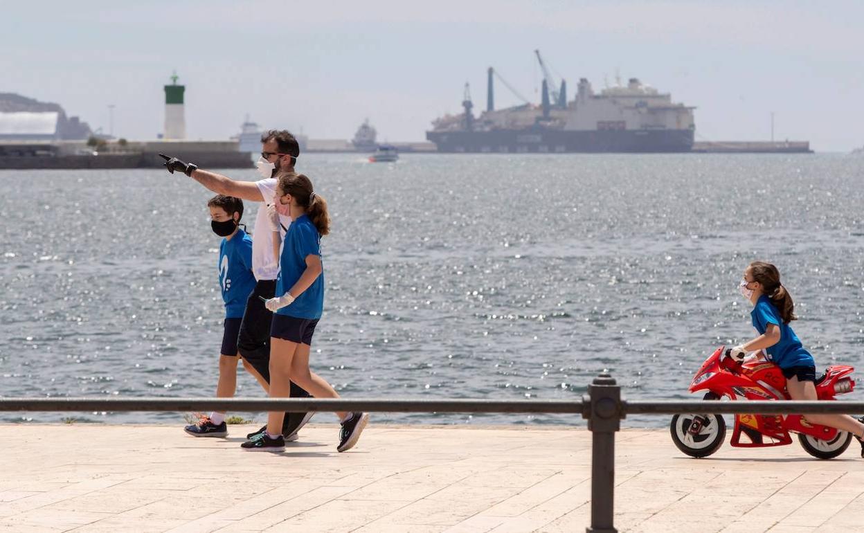 Un padre pasea junto a sus hijos, este martes en el puerto de Cartagena. 