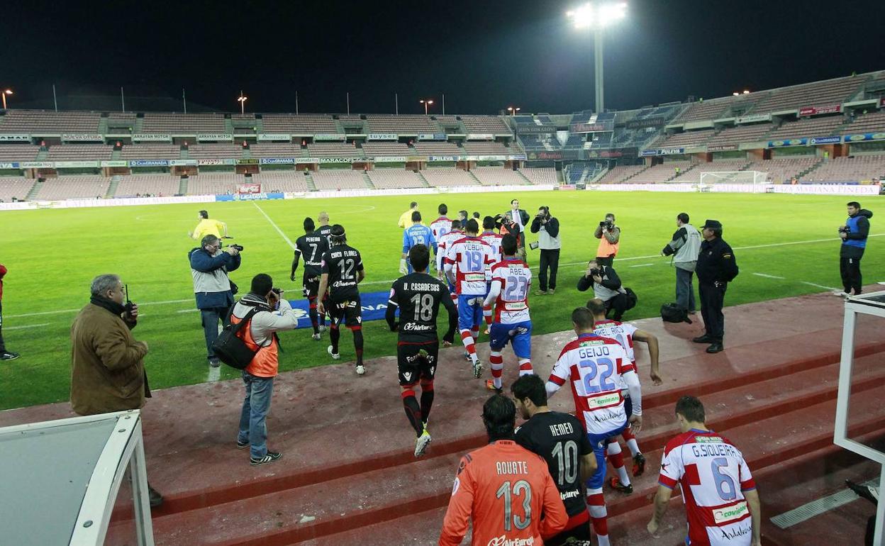 Los futbolistas del Granada y el Mallorca acceden a un Los Cármenes vacío tras el 'paraguazo' de 2011. 