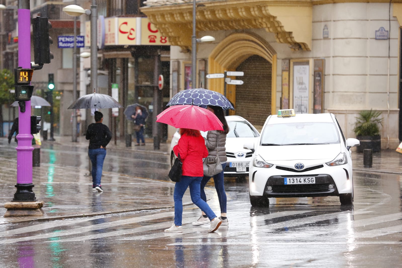 El agua que está cayendo sobre a capital provoca que los granadinos que salen a la calle lo hagan protegidos