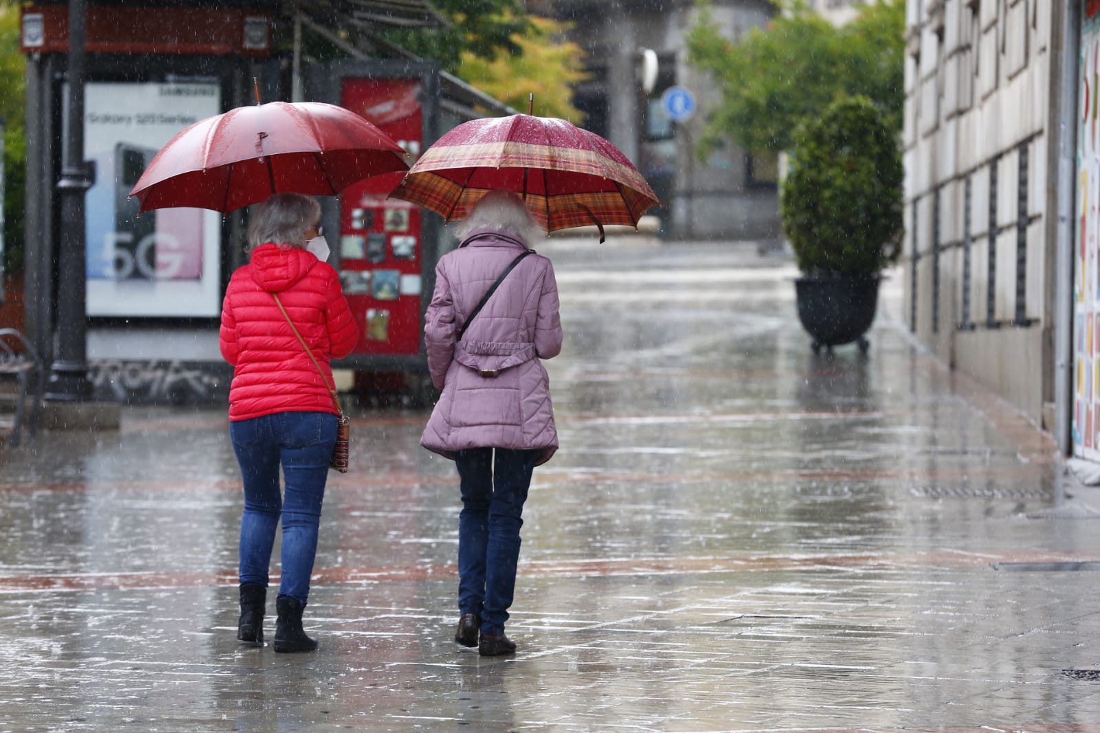 El agua que está cayendo sobre a capital provoca que los granadinos que salen a la calle lo hagan protegidos