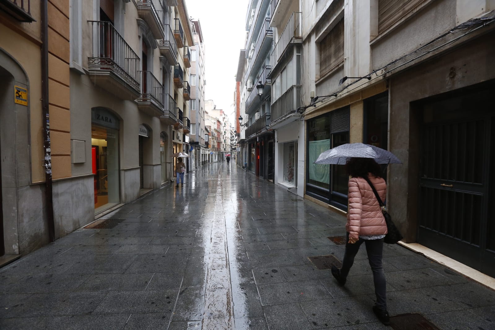 El agua que está cayendo sobre a capital provoca que los granadinos que salen a la calle lo hagan protegidos