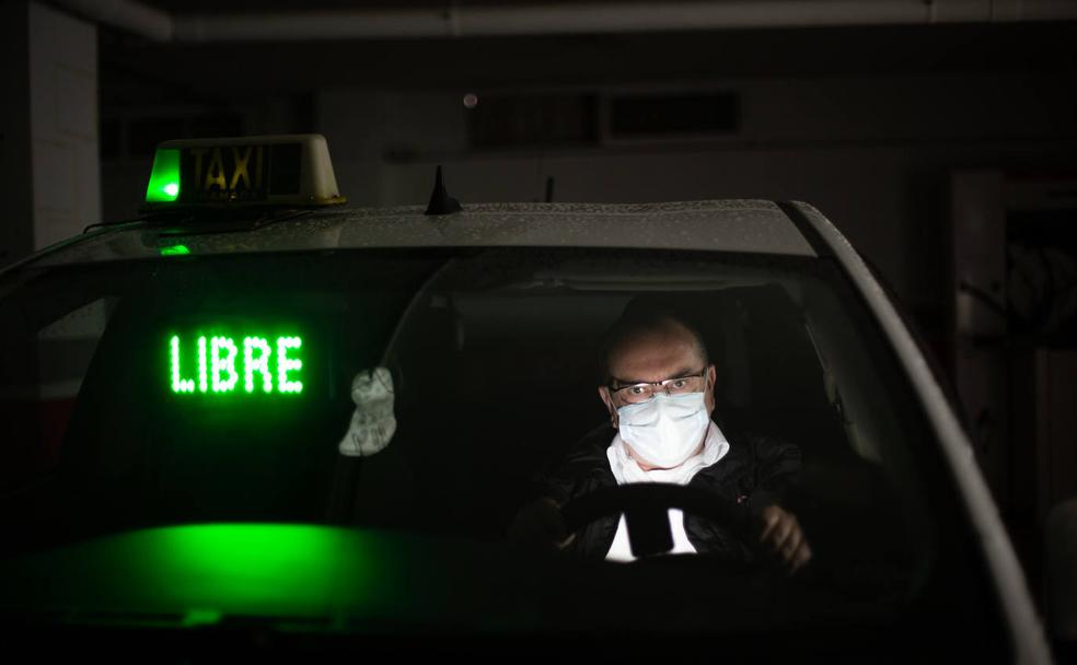 Ramón Alcaraz, con su mascarilla colocada, al volante de su taxi.