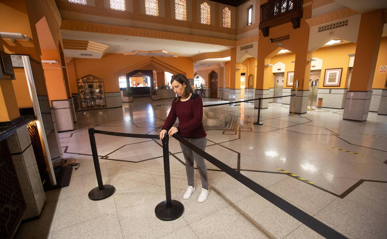 Una empleada coloca los precintos de las zonas comunes en el Hotel Saray, que abre este lunes. 