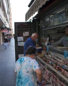 Imagen secundaria 2 - Cafetería en Camino de Ronda; Jonathan, sirviendo desayunos para llevar; y lectores haciéndose con su periódico. 